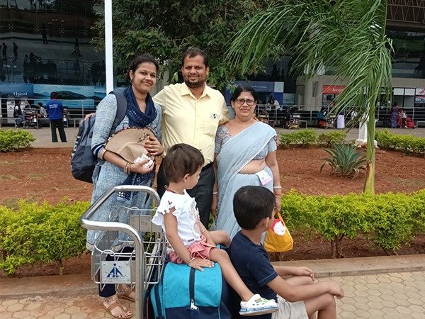 Family with luggage trolley at the airport before their trip